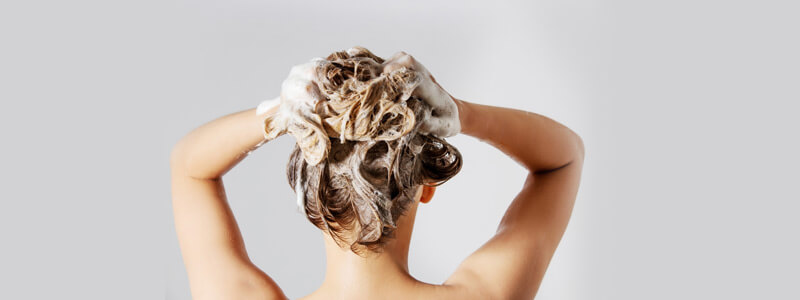 Woman using shampoo on hair